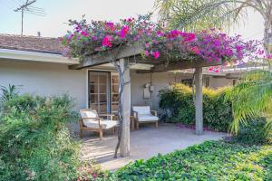 una pérgola con flores rosas en el patio en @ Marbella Lane - Serene Ranch Style Home w/Pool, en Fullerton