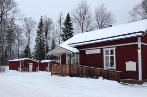 Cabaña roja con nieve en el techo en VLS Stugby, en Åshammar