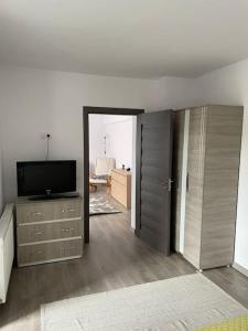 a living room with a flat screen tv and a room at Lady M Apartment in Sighişoara