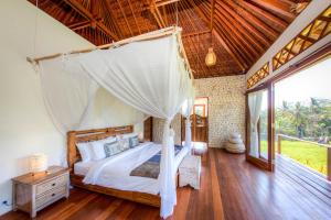 a bedroom with a bed with a mosquito net at The Shala Bali in Ubud