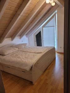 a large bed in a room with a large window at Ferienwohnung Hegau in Hilzingen