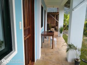 a hallway of a house with a wooden door and a table at Jeno Tourist Inn in San Vicente