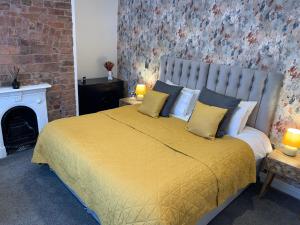 a bedroom with a large bed with yellow sheets and pillows at 46 Ashfield Rd, Altrincham in Altrincham