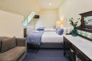 una camera con un grande letto e un divano di Peel Inn Hotel Nundle a Nundle