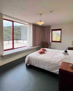 ein Schlafzimmer mit einem Bett und einem großen Fenster in der Unterkunft Villa Michaux in Hastière-par-delà