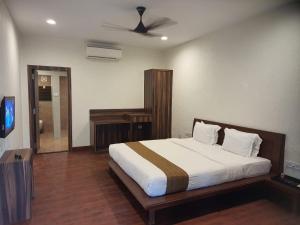 a bedroom with a large bed and a television at Adamo The Village in Matheran