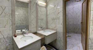 a bathroom with two sinks and a large mirror at شاليه ريست 1 in Hail
