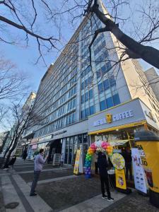 personnes debout devant un immeuble de bureaux dans l'établissement Treehouse, à Incheon