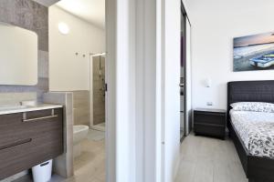 a bedroom with a bed and a bathroom with a sink at Giorgio Home Holiday in Bari Sardo +12 photos