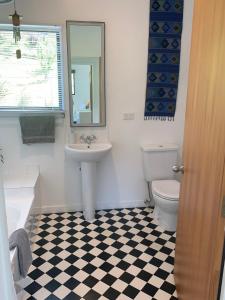 uma casa de banho com um lavatório, um WC e um espelho. em Koru Havenz em Picton