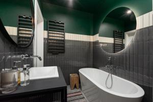 a bathroom with a tub and a sink and a mirror at Pory 57 by Homeprime in Warsaw +13 photos