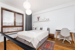 a bedroom with a bed and a desk and a window at Pory 57 by Homeprime in Warsaw