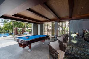 a pool table in a living room with chairs and a pool table at Mason Pine Hotel Bandung in Padalarang