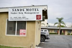 a sign for aiants model under new management on a building at Sands Motel by Ontario Airport & Toyota Arena in Ontario