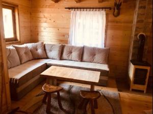 uma sala de estar com um sofá e uma mesa em Etno kuća ''Nada'' em Jahorina