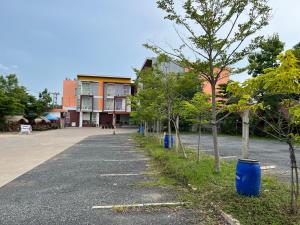 une rue vide avec des arbres devant un bâtiment dans l'établissement โรงแรมช้างใหญ่ใจดี, à Yasothon