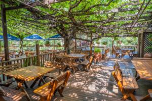 un restaurant avec des tables en bois, des bancs et des arbres dans l'établissement Peel Inn Hotel Nundle, à Nundle