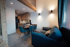 uma sala de estar com um sofá azul e uma mesa em Studio Interlude by ExplorHome em Tignes