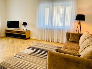 een woonkamer met een bank en een flatscreen-tv bij Cozy Reimani Residence - City Heart Free Parking in Tallinn