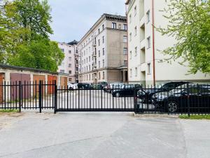 een zwart hek met auto's geparkeerd voor gebouwen bij Cozy Reimani Residence - City Heart Free Parking in Tallinn
