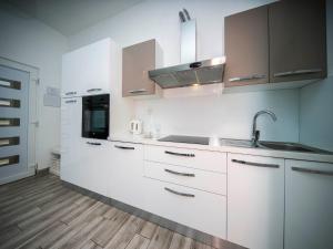 - une cuisine avec des placards blancs et un évier dans l'établissement Holiday Home Relax, à Podstrana