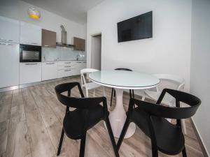 une cuisine avec une table blanche et des chaises noires dans l'établissement Holiday Home Relax, à Podstrana