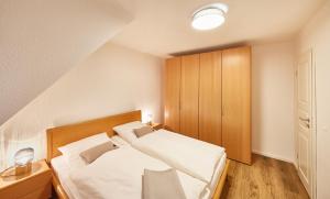 ein kleines Schlafzimmer mit einem Bett und einem Schrank in der Unterkunft Ferienwohnung mit Meerblick Grimmershörnbucht in Cuxhaven