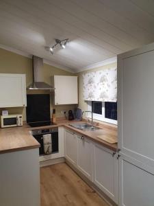 a kitchen with white cabinets and a sink and a stove at The Lodge at Meadow Hope in Hereford