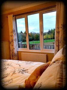 una camera con letto e finestra di The Lodge at Meadow Hope a Hereford