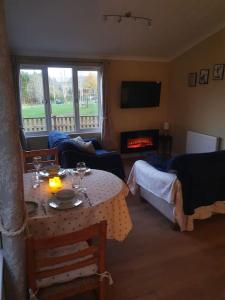 a living room with a table and a couch at The Lodge at Meadow Hope in Hereford