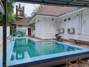 une piscine en face d'une maison dans l'établissement Whitehouse cafe&Guesthouse, à Ban Sa La