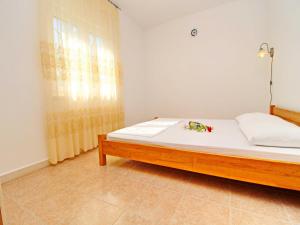 a bedroom with a bed with white sheets and a window at Oasis of Paradise in Žrnovo