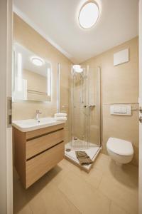 ein Bad mit einer Dusche, einem Waschbecken und einem WC in der Unterkunft Ferienwohnung mit Meerblick Grimmershörnbucht in Cuxhaven