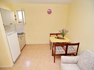 a living room with a table and chairs and a kitchen at Oasis of Paradise in Žrnovo