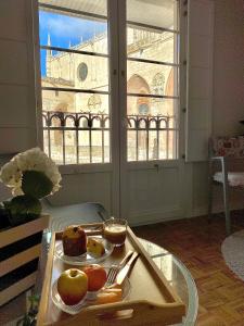 bandeja de comida en una mesa en una habitación con ventana en Puerta al cielo Suite, en Burgos