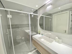 a bathroom with a shower and a sink and a mirror at 12 Shimon HaTzadik - By Beach Apartments TLV in Tel Aviv