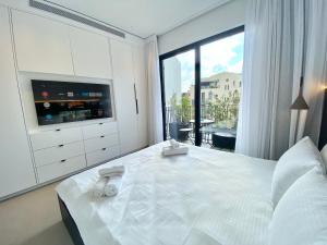 a bedroom with a large white bed and a large window at 12 Shimon HaTzadik - By Beach Apartments TLV in Tel Aviv