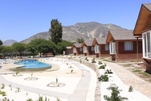 a resort with a swimming pool in front of houses at Hotel El Bramador in Copiapó