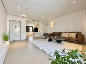 a living room with a couch and a table at 12 Shimon HaTzadik - By Beach Apartments TLV in Tel Aviv