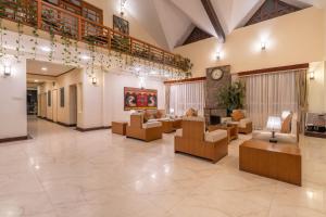 a lobby with couches and tables and a clock at Summit Lillium Hotel & Spa in Kalimpong