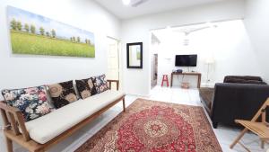 un soggiorno con divano e TV di The Penggawa Homestay - 3 comfortable bedrooms a Johor Bahru