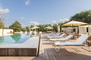 a row of lounge chairs next to a swimming pool at Hotel Rural Xereca in Puig D’en Valls