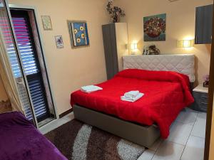 a bedroom with a red bed with towels on it at Golden Dreams Reggio Calabria in Reggio di Calabria
