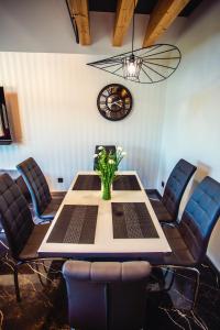 uma sala de jantar com mesa e cadeiras e um relógio em Apartament LUX Ustroń em Ustroń