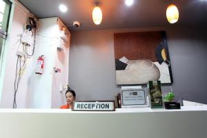 a woman sitting behind a counter in a room at Del Mar Rooms in Pattaya South
