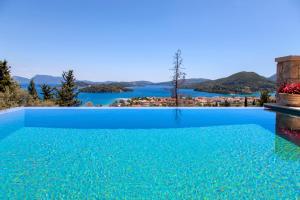 a large blue swimming pool with a view of the water at Villa Kallisto in Nydri