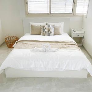 sypialnia z białym łóżkiem z białą pościelą w obiekcie Lux & Comfy ~ Pool ~ Queen Beds w mieście Riszon le-Cijjon