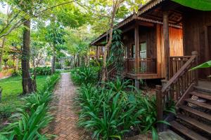 a wooden house with a pathway leading to it at Dontrei Villa Angkor in Siem Reap
