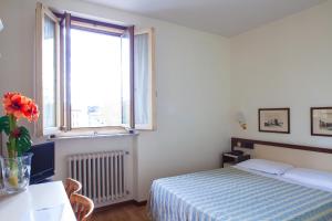 una camera con letto e finestra di Hotel San Marco a Prato