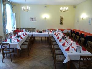a large room with tables and chairs with red napkins at Hotel Garni am Schlosspark in Wernigerode